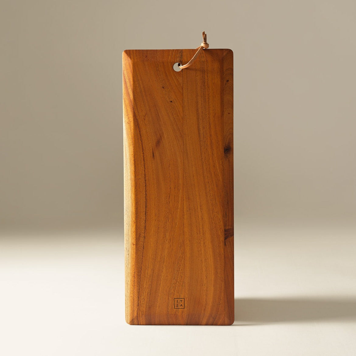 Brown wooden cutting or serving board displayed on a gray and white background