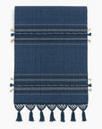 Navy blue woven table runner with decorative tassels on a white background