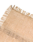 A beige jute table runner with a fringed edge, displayed on a white background