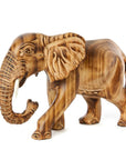 A sculpture of a jacaranda wood elephant with burned contours and cow bone tusks, unpainted and whimsical in style