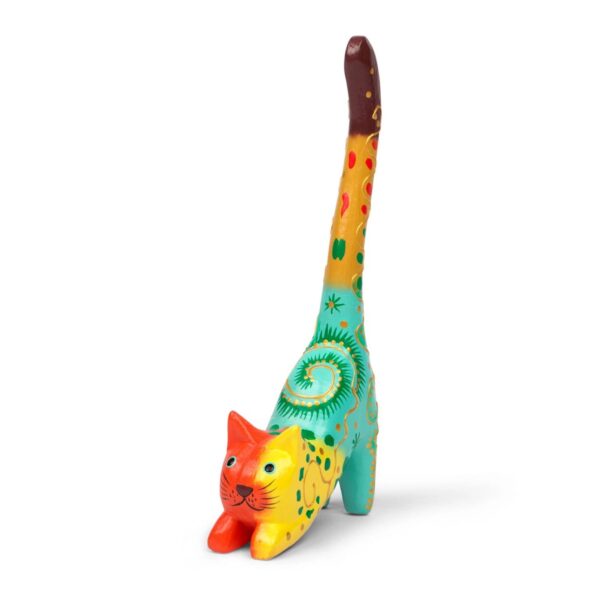 A hand-carved and hand-painted wooden ring holder in the shape of a cat with colorful patterns.