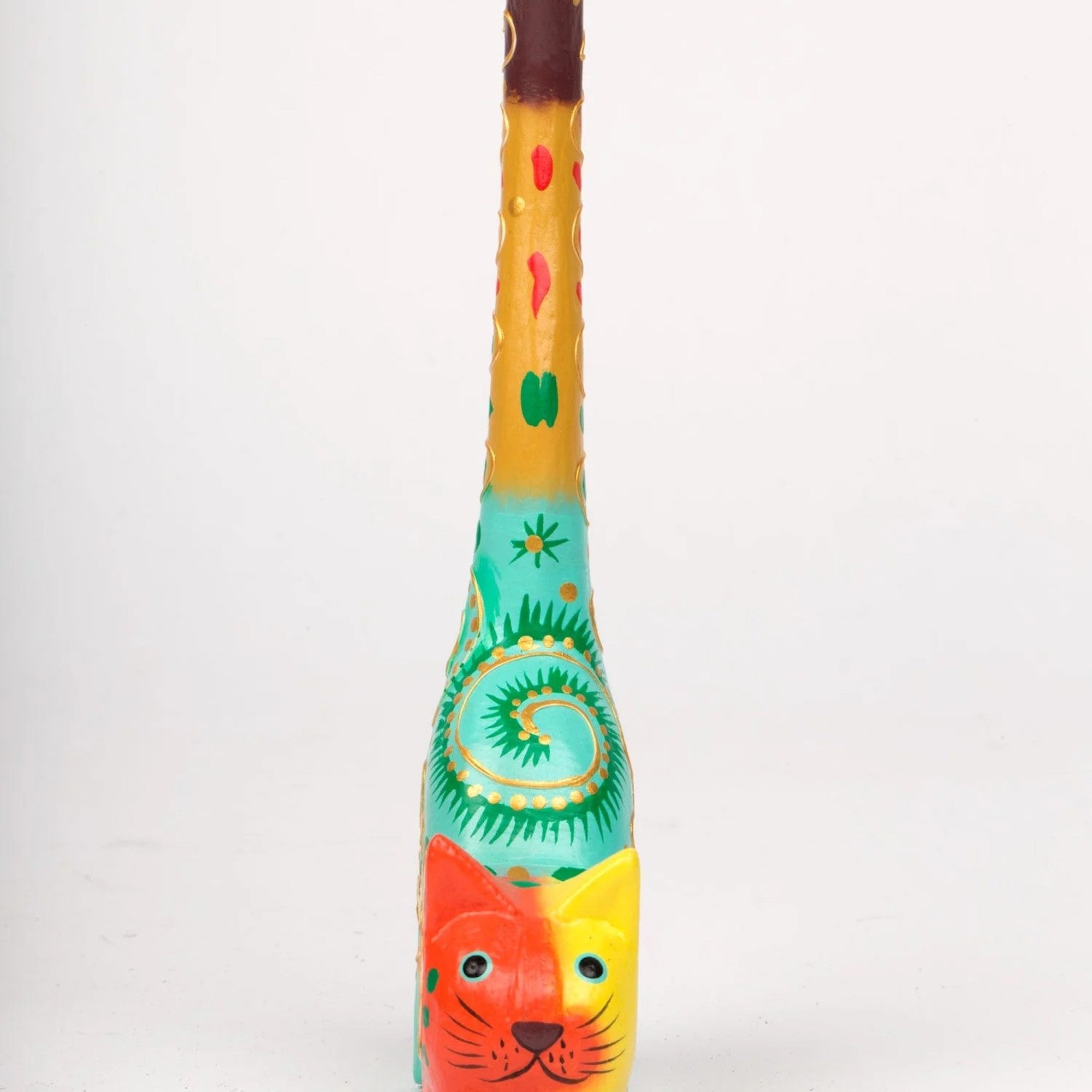 A hand-carved and hand-painted wooden ring holder in the shape of a cat with colorful patterns from the front.