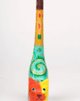 A hand-carved and hand-painted wooden ring holder in the shape of a cat with colorful patterns from the front.