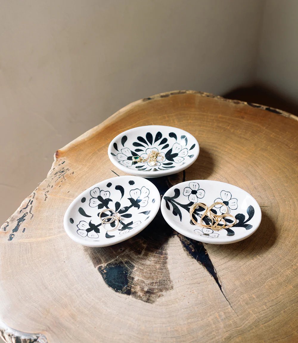 Three small ceramic dishes with floral patterns on a wooden surface