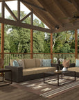 Outdoor patio with wooden deck, sofa, and chairs surrounded by trees on a Navajo outdoor mat