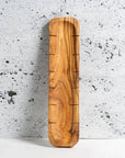 A long, narrow olive wood bread slicing board with a natural, rustic finish