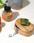 Wooden jewelry box with a green stone on top, surrounded by other decorative items.