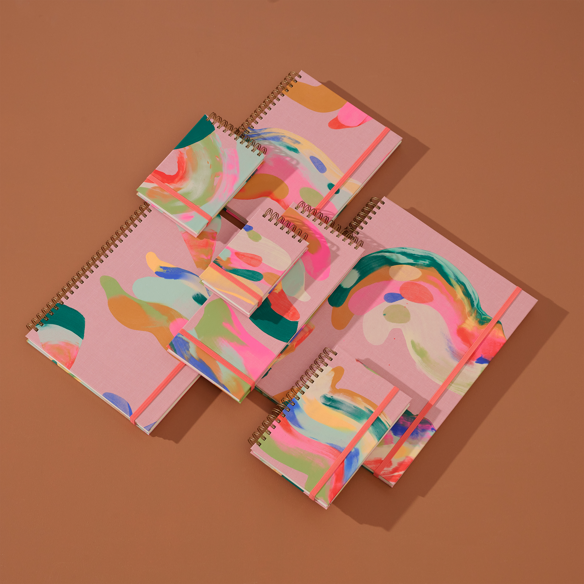 Colorful spiral-bound notebooks on a brown background
