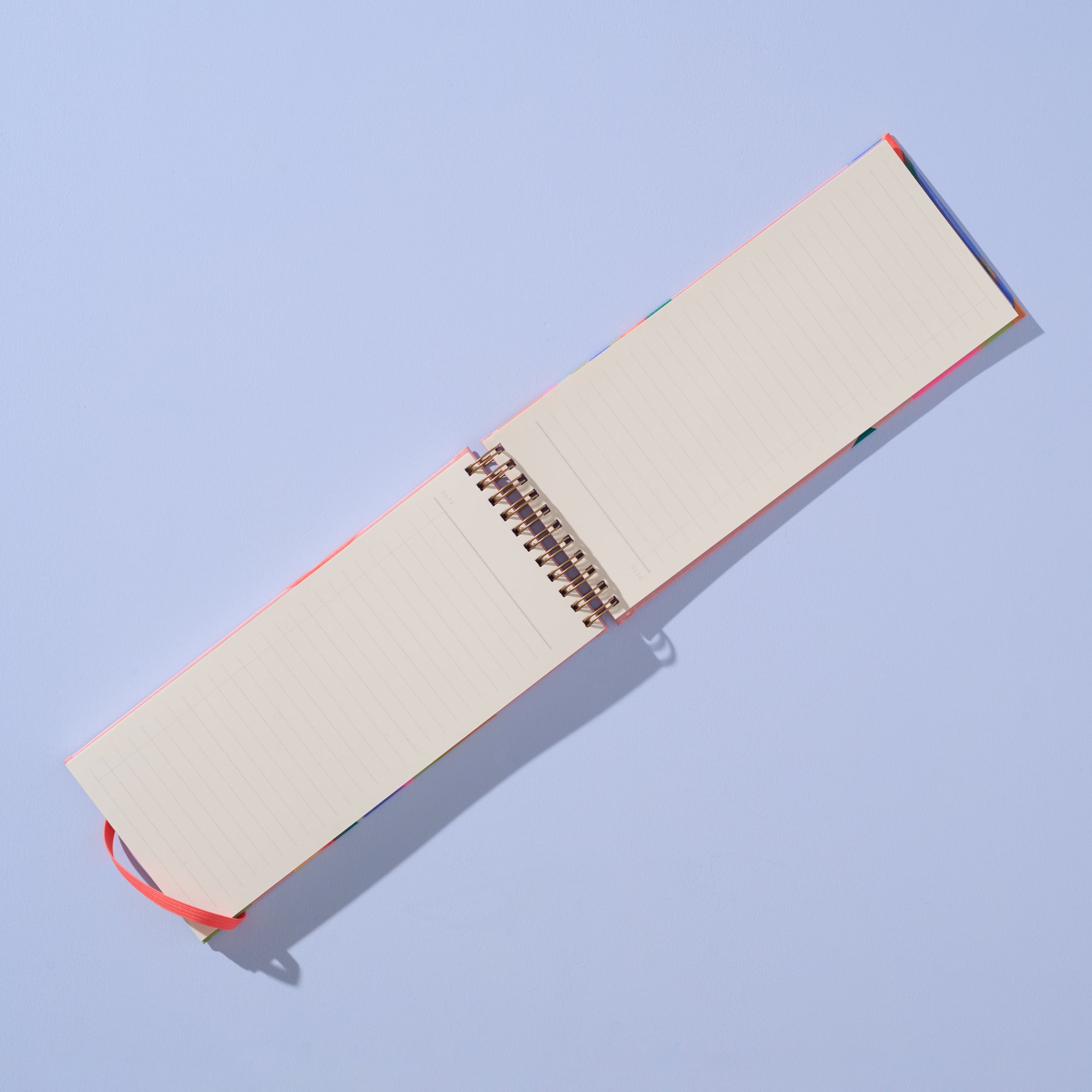 Open notebook with beige pages and red binding on a light blue background