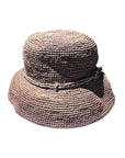 A pink raffia hat with a round shape and a flat brim, featuring a decorative ribbon around the crown.