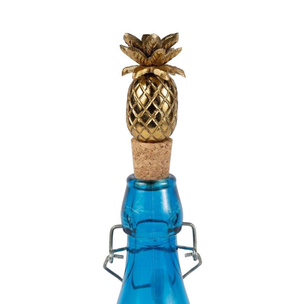 Blue bottle with a gold pineapple-shaped cork stopper on a white background