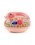 A decorative pink papier-mâché bunny box with floral patterns and a painted face.