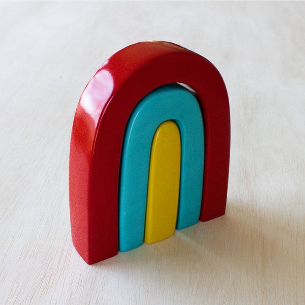 Colorful wooden rainbow sculpture on a light wooden surface