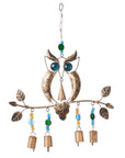 A bronze-colored iron owl wind chime with blue-glass eyes, brass branch, colorful glass beads, and small iron bells hanging from a chain
