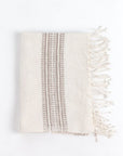 Beige towel with striped pattern and fringes on a white background
