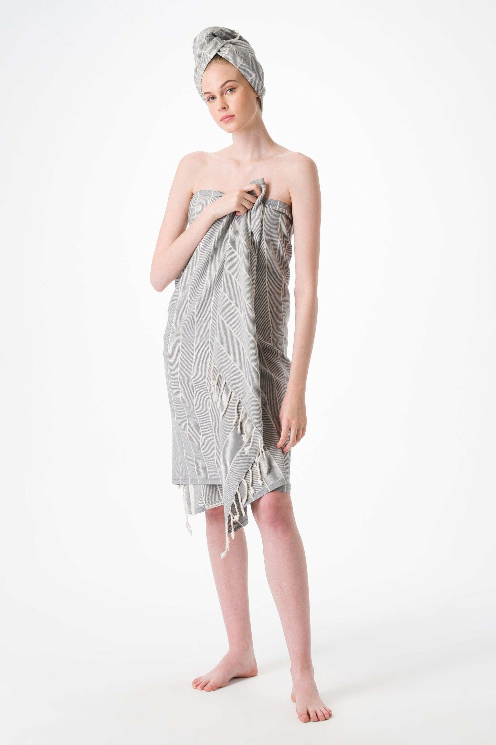 Woman wearing a gray striped towel on a white background