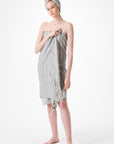 Woman wearing a gray striped towel on a white background