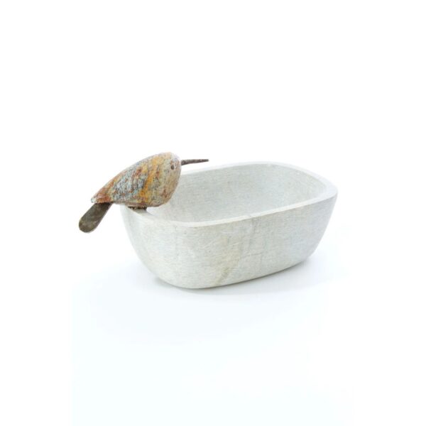 A handcrafted oval-shaped serpentine stone dish with a polished bird perched on the edge, displayed against a white background