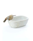 A handcrafted oval-shaped serpentine stone dish with a polished bird perched on the edge, displayed against a white background