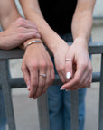 Two models with two hands wearing .925 sterling silver ring sets.