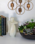 Handmade stone sculpture of a person in a thoughtful pose next to three books