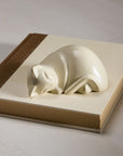 White stone cat figurine on a book cover.
