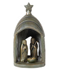 A terracotta nativity scene featuring figures of Mary and Joseph standing beside a manger, with a stable structure and a star on top