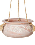 A terracotta hanging planter with etched leaf patterns and a jute hanger