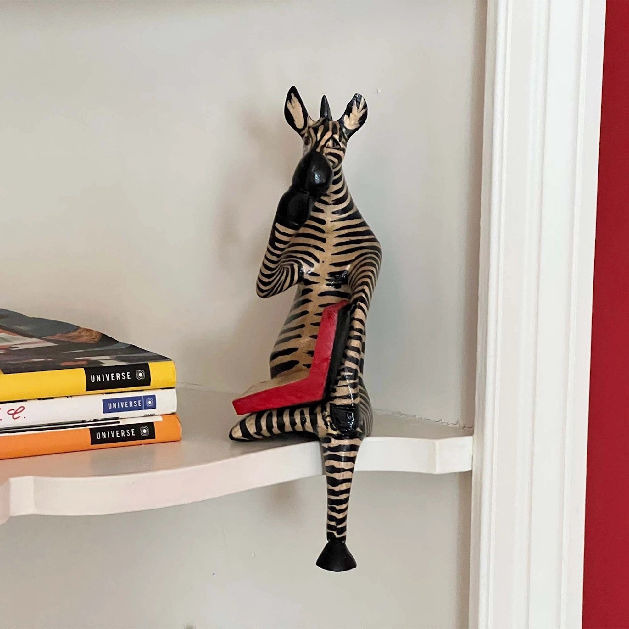 A handmade wooden zebra ledge lounger on a shelf
