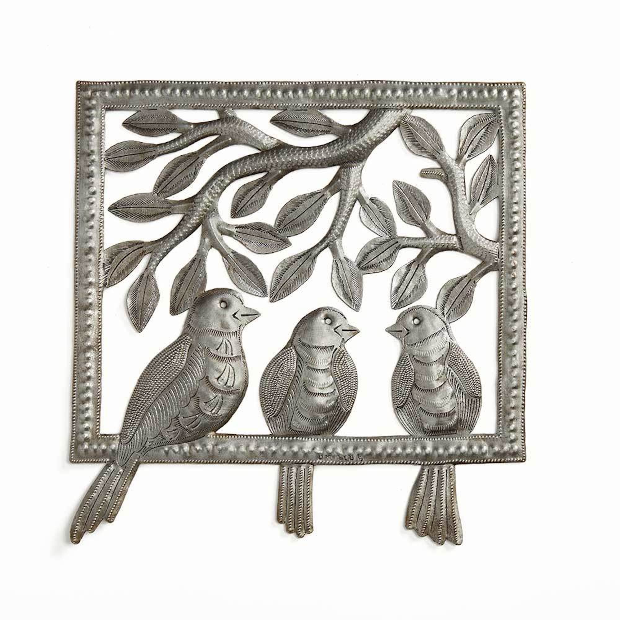 A metal wall art depicting three birds perched on a leafy tree, with a decorative border