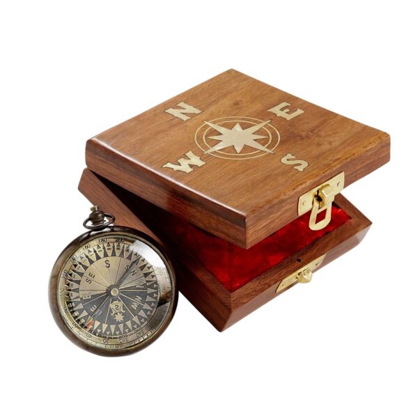 A navigational compass with a sheesham wood box, featuring a metal body and a glass face, with the box lid open and a red velvet lining visible.