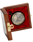 A navigational compass with a sheesham wood box, featuring a metal body and a glass face, with the box lid open and a red velvet lining and compass visible.