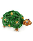 Beaded turtle figurine with green shell and brown body on a white background