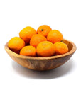 A handcarved olive wood bowl filled with orange fruits, displayed on a white background