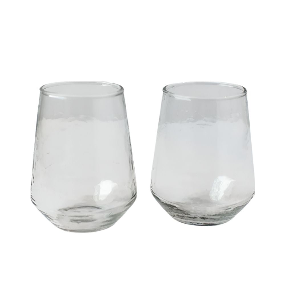 Two handblown hammered clear drinking glasses with a solid pattern and no visible contents