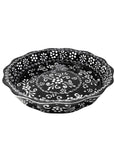 A black and white handmade pottery serving dish with a floral pattern