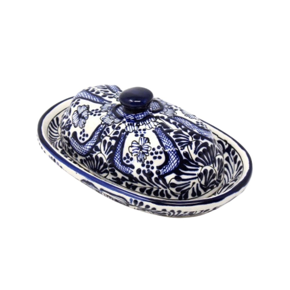 A handmade ceramic butter dish with a blue floral pattern on a white background, crafted by Encantada