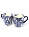 A set of two traditional Mexican pottery mugs with blue floral patterns on a white background
