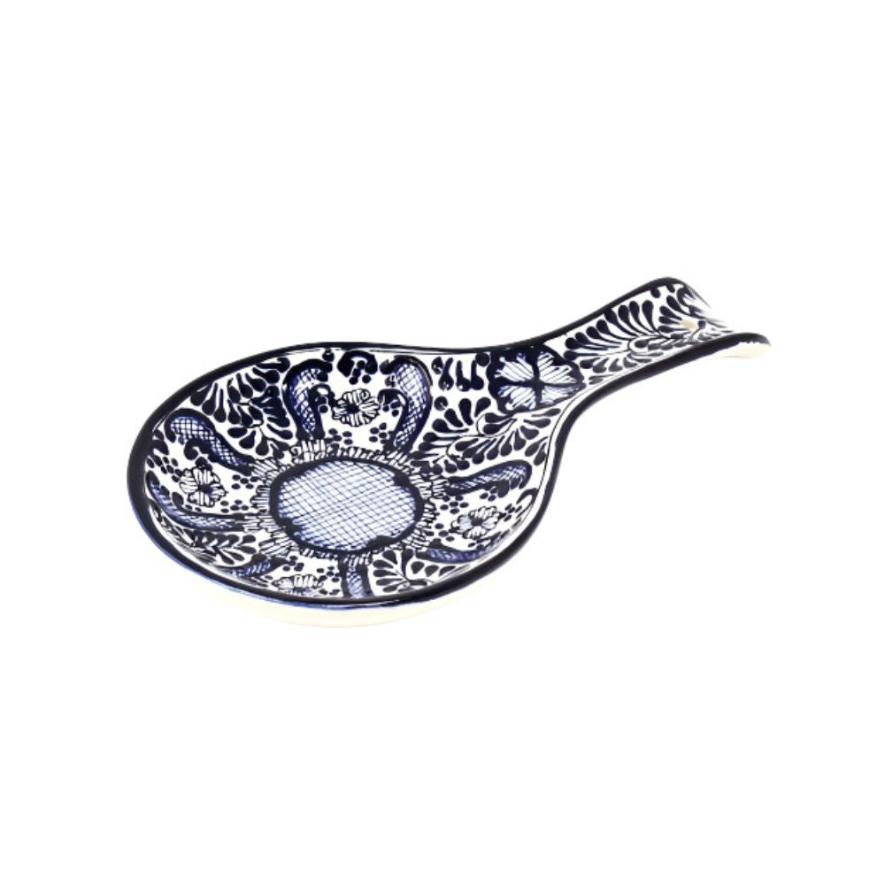 A handmade blue and white floral patterned pottery spoon rest