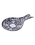 A handmade blue and white floral patterned pottery spoon rest
