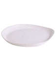 A round, white stoneware serving platter with a simple and elegant design, hand-crafted with visible edges and a smooth surface