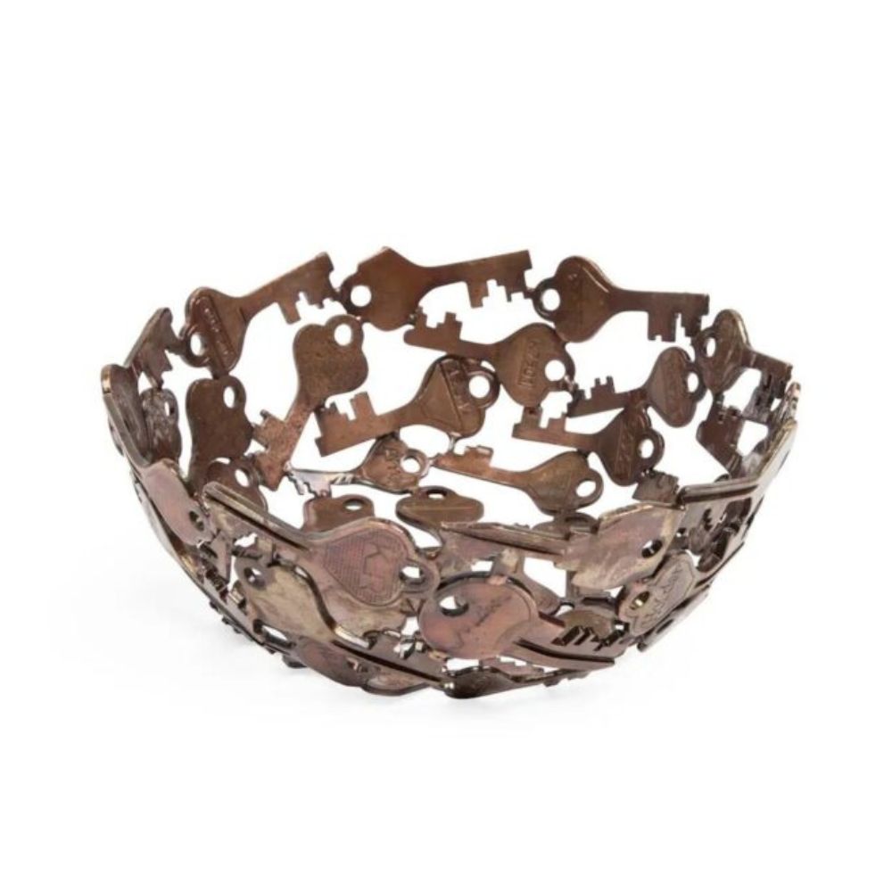 A handcrafted decorative bowl made of assorted recycled iron keys with a copper-colored finish.
