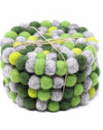 A stack of round felt ball coasters in various shades of green and gray, tied together with string