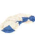 A set of four macrame coasters with a fringe, predominantly in blue and beige colors