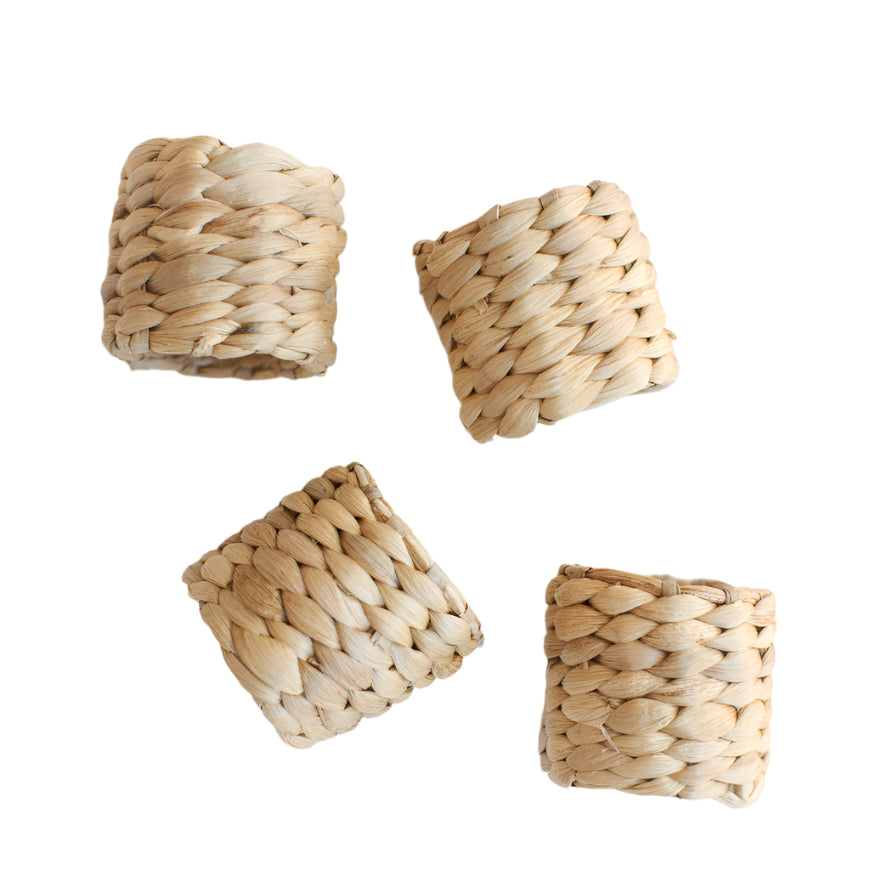 A set of four beige napkin rings made from woven water hyacinth