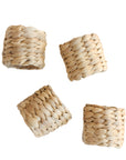 A set of four beige napkin rings made from woven water hyacinth