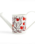 White watering can with red floral design on a white background