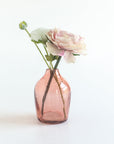 Pink glass vase with flowers on a white background