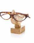 A pair of glasses resting on a wooden stand carved in the shape of a cardinal