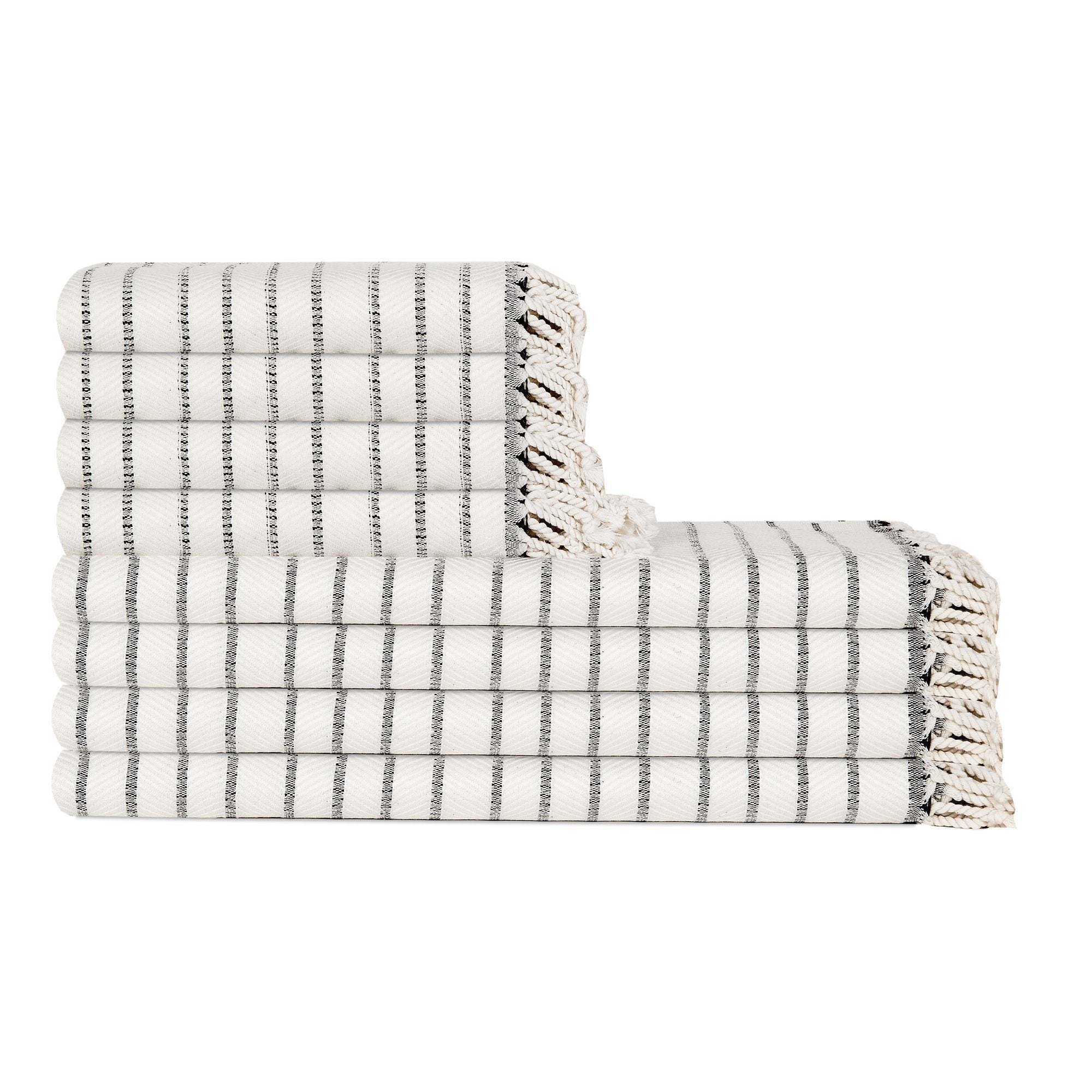 Stack of white and gray striped towels with fringed edges on a white background